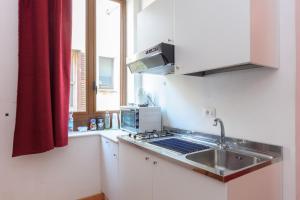 トラーパニにあるAppartamenti Trapani Mareのキッチン(シンク、コンロ付)、窓が備わります。
