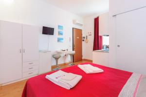 トラーパニにあるAppartamenti Trapani Mareのベッドルーム1室(赤いベッド1台、タオル2枚付)