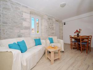 een woonkamer met een witte bank en een tafel bij Apartment Petrovic in Trogir