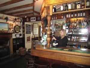 a woman sitting at a bar in a pub at Port Charlotte Hotel in Port Charlotte