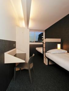Una habitación de hotel con dos camas, un escritorio y una silla. en FIAP Paris, en París 37 fotos más