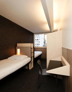 Una habitación de hotel con dos camas, un escritorio y una ventana. en FIAP Paris, en París