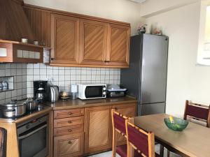 a kitchen with a table and a microwave and a refrigerator at Family House in Kavála