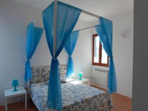 トッレ・スーダにあるVilla Giordanoのベッドルーム1室(青い天蓋付きベッド、青いカーテン付)