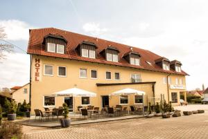 a building with tables and chairs in front of it at Hotel Zum Hirsch in Römhild