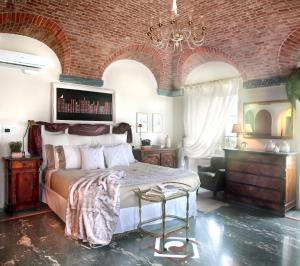 a bedroom with a large bed and a brick wall at Villa Ottolenghi Wedekind in Acqui Terme