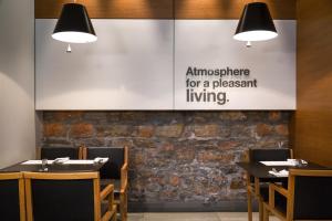 an empty restaurant with two tables and a large sign on the wall at Aegli Hotel Volos in Volos