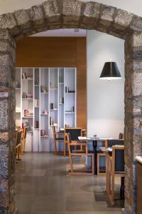 Aegli Hotel Volos في فولوس: ممر في غرفة الطعام مع الطاولات والكراسي