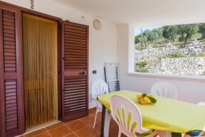 a dining room with a green table and white chairs at Villa Calma in Vieste