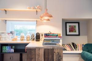 a kitchen with a counter with a stack of books at Helen Browning's Royal Oak in Swindon