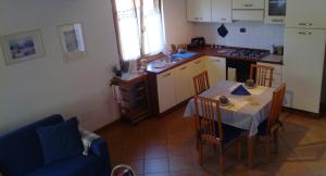 uma cozinha com uma mesa e cadeiras e uma cozinha com uma mesa e uma cozinha em B&B I Pioppi em Chiavenna