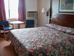Habitación de hotel con cama, mesa y sillas en Economy Inn Wentzville, en Wentzville