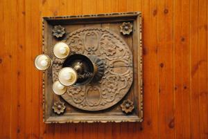 a clock on a wooden wall with lights on it at Kirkit Hotel in Avanos