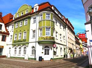 un edificio bianco e verde su una strada di Hotel Döbelner Hof a Döbeln