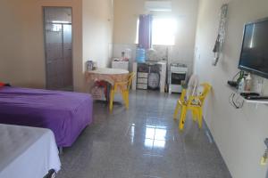 a bedroom with a purple bed and yellow chairs at Pousada Recanto Cruzeiro in Barreirinhas