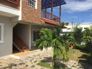 uma casa com uma palmeira em frente em Blue Acuarela em Cabrera