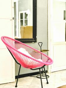 une chaise rose assise devant un miroir dans l'établissement Casa Bolsa43, à Sanlúcar de Barrameda