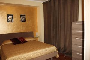 een slaapkamer met een bed, een dressoir en een raam bij Villa Cattleya in Campofelice di Roccella