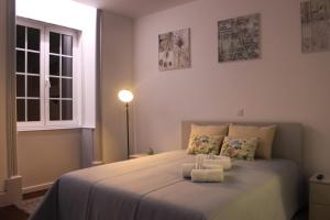 a bedroom with a bed with two towels on it at Charme e Alegria in Viseu