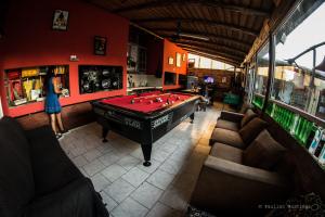 a woman standing in a room with a pool table at Carrusel Art-Hostel in Mar del Plata