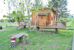 una casa en el árbol con un banco y una mesa en L'Etournelle - Cabane Perchée en Chaussan