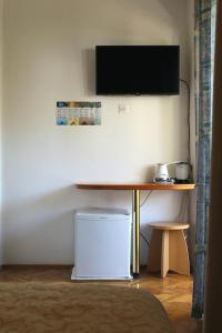 a desk with a television and a table with a laptop at Rooms Nadia3 in Baška