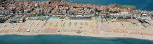 - une vue aérienne sur une plage avec une foule de personnes dans l'établissement Hotel Medusa, à Sottomarina