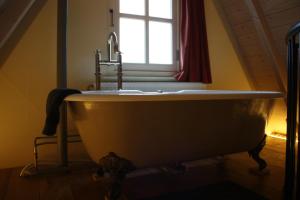 a bath tub in a bathroom with a window at De Hemel De Kracht van Ambacht in Nijmegen