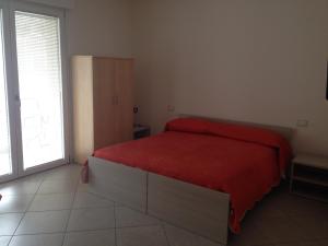 una camera con un letto con una coperta rossa di Casa Armonia a Peschiera del Garda