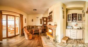 a living room with a fireplace and a table at Bajeczny domek Andrzejówka in Polańczyk