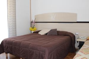 una camera da letto con un grande letto con una coperta marrone di Hotel Allo Zodiaco ad Andalo