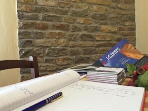 a desk with a stack of books and a notebook at Agriturismo Finestre di Langa in Trezzo Tinella