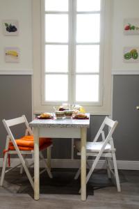 un tavolo con due sedie e un tavolo con il cibo sopra di Max Apartment a Verona