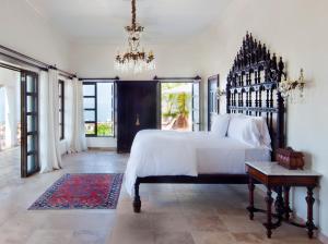 a bedroom with a large bed and a chandelier at Casa Kimberly Boutique Hotel in Puerto Vallarta