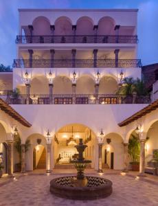 um pátio com uma fonte em frente a um edifício em Casa Kimberly Boutique Hotel em Puerto Vallarta