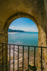 a view of the ocean through an arch in a wall at Casa Del Lavatoio in Cefalù