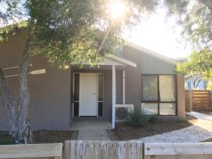 a house with a wooden fence in front of it at Beach House Getaway 2 in Smiths Beach