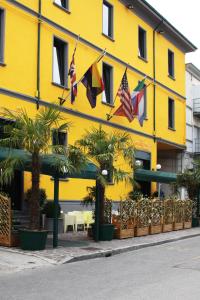 a yellow building with flags in front of it at Residence H5 in Piacenza