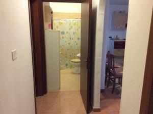 an open door to a bathroom with a toilet at Villa Matine in Specchia