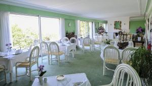a dining room with white tables and white chairs at Villa Ric in Saint-Céré