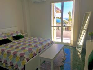a bedroom with a bed and a table and a window at Villa Alba in Acitrezza