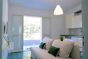 a living room with a white couch and a kitchen at Villa Alba in Acitrezza