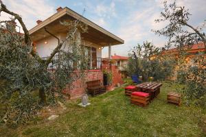 een achtertuin met een tafel en stoelen en een huis bij La Casina Del Canneto in Pergine Valdarno