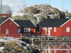 a group of red buildings in front of a mountain at Lofotbo in Stamsund