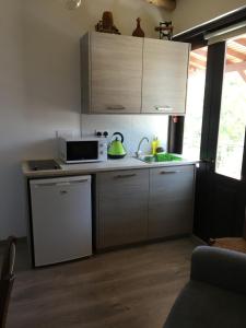 uma pequena cozinha com um micro-ondas e um lavatório em Xenios Guesthouse em Koilani