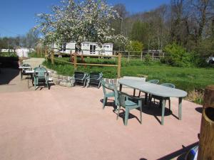a group of tables and chairs on a patio at Etretat's Motel in Étretat