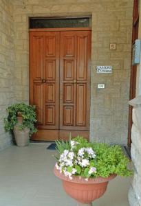 アッシジにあるCamere Tizianaの大きな木製のドア(花の鉢付)