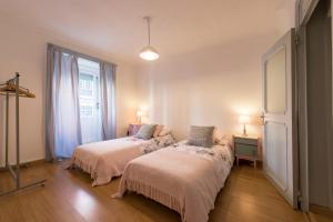 a bedroom with two beds and a window at Downtown Doll's House in Lisbon