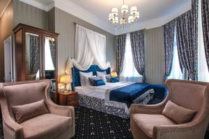 a bedroom with a blue bed and two chairs at Boutique Hotel Onyx in Saint Petersburg