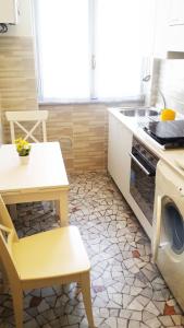 cocina con mesa y lavadora en Edolo Apartment en Milán